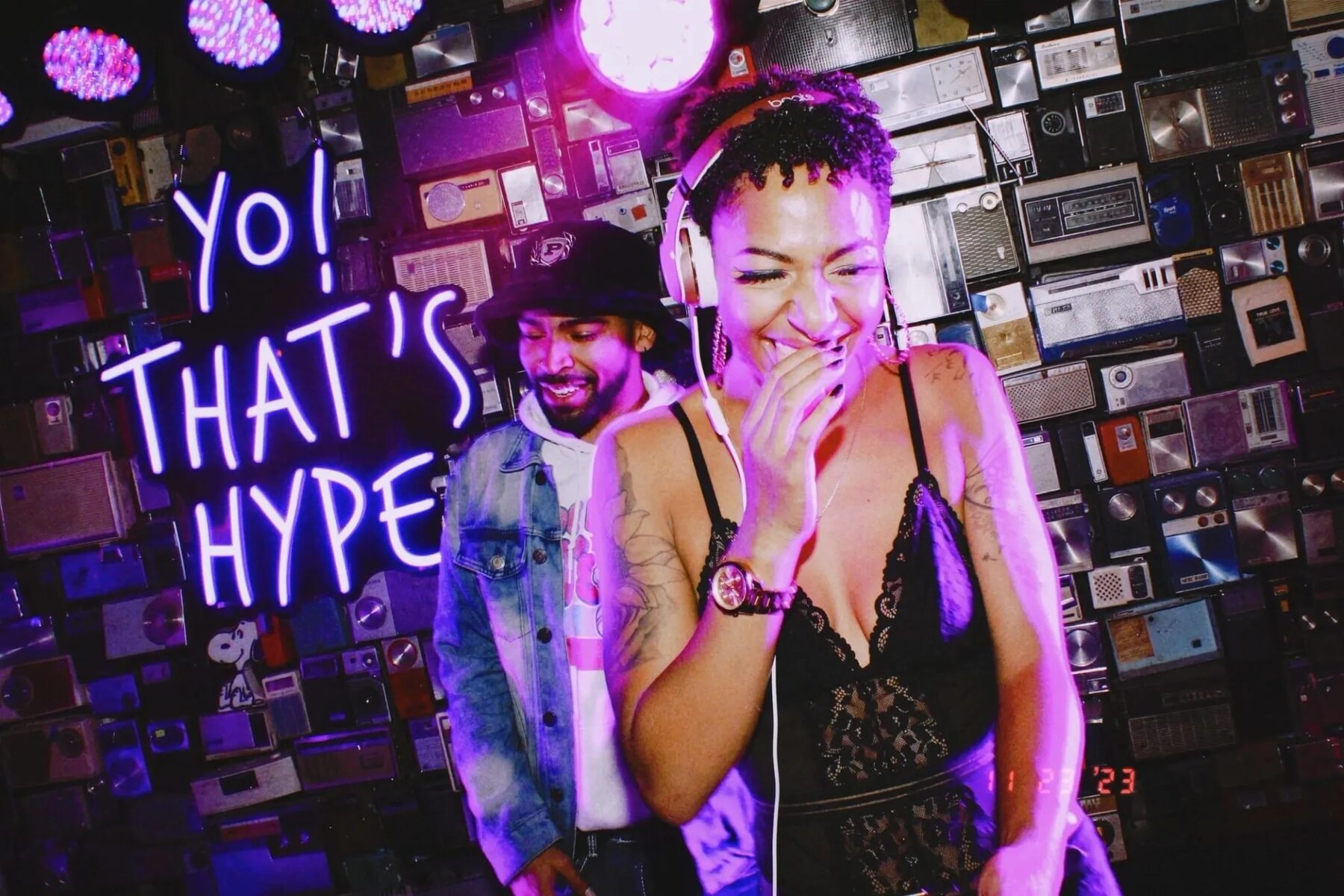 DJ Mahay performing in front of a neon sign