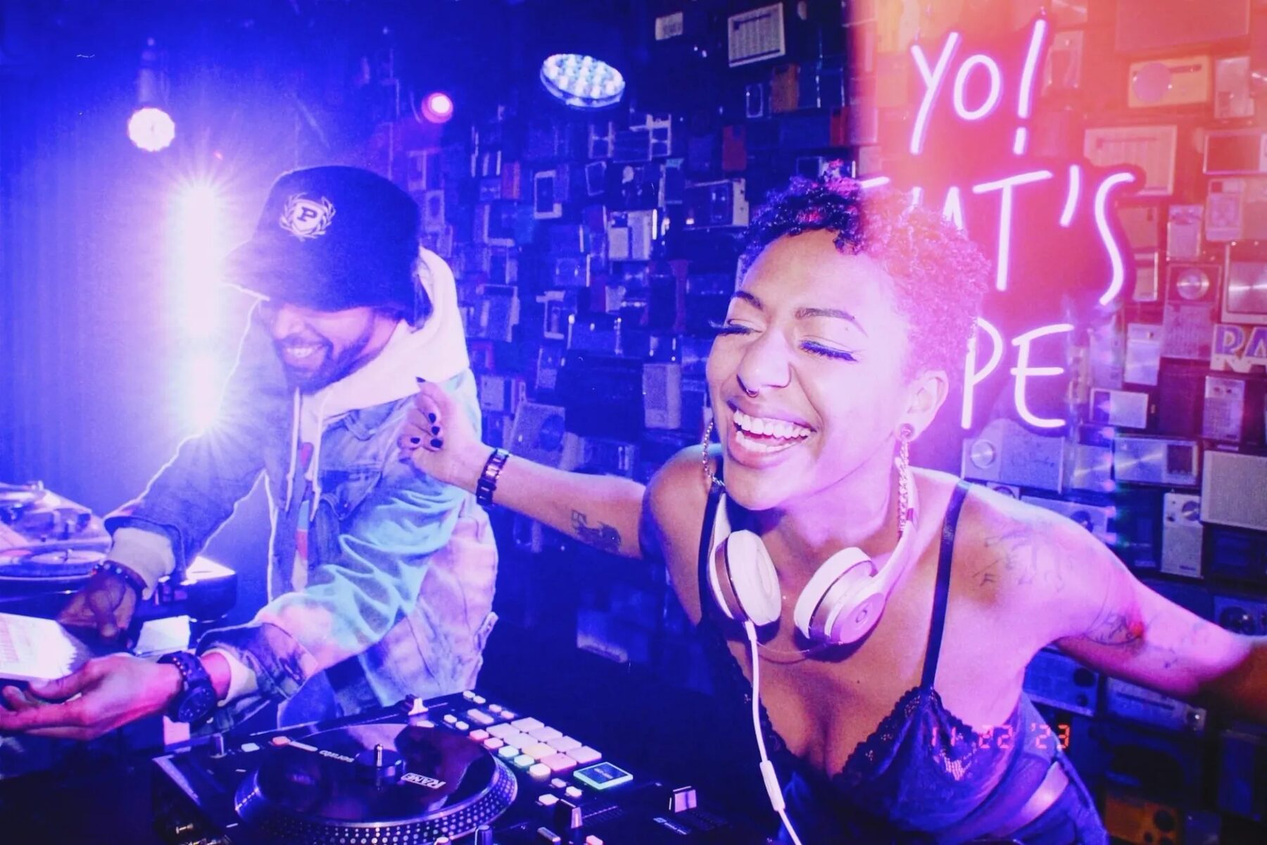 DJ Mahay laughing mid-set under neon lights