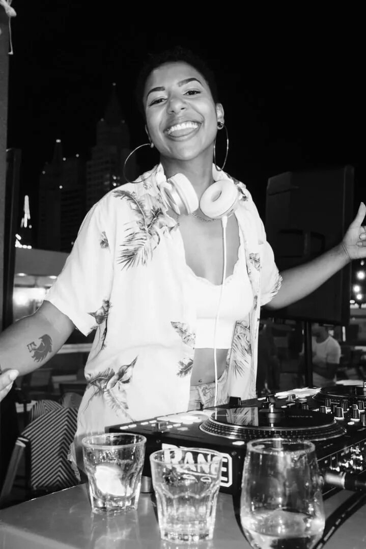 DJ Mahay laughing at a rooftop set with the Las Vegas skyline behind her